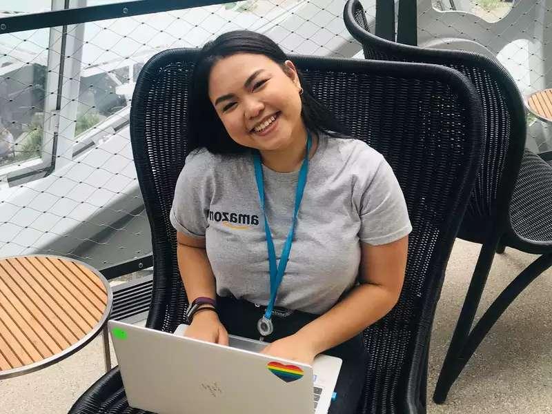 Kim Samala wearing an Amazon t-shirt, working on a laptop